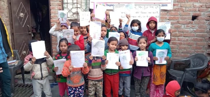 Children in a learning circle holding up their drawings outdoors